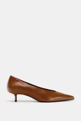 Zapato de tacón bajo tipo kitten, confeccionado en piel color marrón, con diseño de punta fina.
