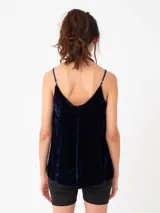 Top negro de terciopelo con breteles finos regulables y escote en V. La parte trasera es más larga que la delantera.
