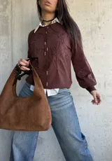 Sweater de tejido de punto color chocolate, con diseño de flores bordadas en relieve, cuello redondo y mangas largas con puños elásticos.
