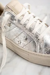 Zapatillas plateadas con apliques de estrellas negras, de cuero legítimo.