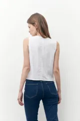 Chaleco blanco de lino con escote en V y cierre frontal con botones. Diseño sastrero con bolsillo de parche en el frente.