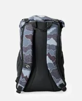Mochila Rip Curl modelo Dawn Patrol 30L Search, de diseño estampado tipo camuflado en tonos gris, azul y negro. Cuenta con compartimento principal tipo rollo, bolsillos frontales con cierre, bolsillo lateral de malla para botella, correas ajustables y base negra reforzada.