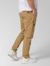 Pantalon Caterpillar de twill elastizado en color beige, con bolsillos laterales tipo utilitario, detalle de etiqueta con logo de la marca y corte ajustado.
