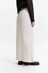 Falda larga color crema, de corte recto y cintura elastizada con lazo ajustable.