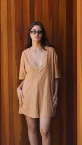Mono corto versátil de lino color camel, con cuello en V profundo, mangas cortas y bolsillos laterales. Diseño holgado con posibilidad de uso reversible.