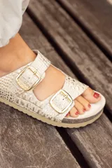 Sandalias de cuero color beige con estampado croco, dos hebillas doradas ajustables y plantilla anatómica.