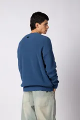 Sweater de tejido de punto acanalado en color azul, con cuello redondo, mangas largas y calce relajado.