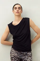 Top sin mangas de modal color blanco, con cuello a la base y fruncidos tipo drapeado en los laterales.