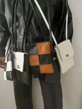 Bandolera pequeña con diseño de tablero de ajedrez en cuero sintético color negro y marrón.