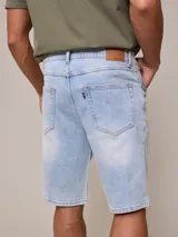 Bermuda de jean elastizado azul claro, con bolsillos delanteros y traseros.