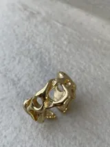 Anillo de bronce con diseño orgánico y aberturas irregulares.