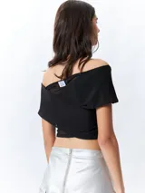 Top negro con estampado floral, escote off-shoulder, corte cruzado y mangas cortas.