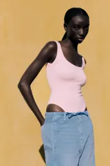 Body negro de escote redondo y tirantes anchos. Cierre inferior con botones a presión. Tejido de punto acanalado.