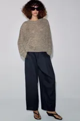 Jersey de punto con hilo metalizado, cuello redondo y manga larga, de diseño clásico y acabado texturizado.