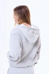 Buzo con capucha y cierre frontal completo, confeccionado en felpa suave, con bolsillos tipo canguro y cordones ajustables en la capucha.