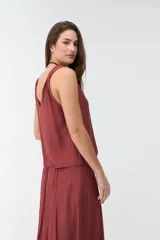 Musculosa bordó de tejido satinado, con escote en V y breteles con detalle de nudos en los hombros.