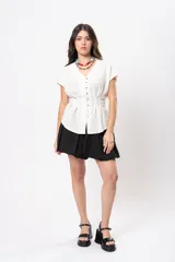 Top negro de diseño versátil con tirantes finos, silueta abombada, elástico en la espalda y hebilla forrada en el frente.