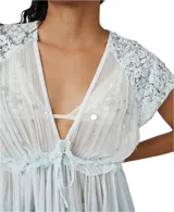 Túnica celeste de gasa con apliques de encaje y lentejuelas. Tiene escote en V, mangas cortas y cintura con cordón ajustable.