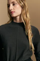 Polera de tejido de punto color marrón, con cuello alto y diseño de líneas verticales en el frente que aportan estructura. Presenta un calce relajado y mangas largas con puños ajustados.