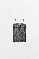 Top de encaje semitransparente con escote recto, tirantes finos y cierre posterior con lazadas.