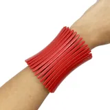 Pulsera ancha de resina color hueso, con diseño de barras alargadas y unidas entre sí por un elástico.
