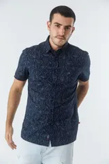 Camisa de hombre Mistral con look lino, de manga corta y corte slim. Presenta un estampado lineal de flores en color azul sobre fondo blanco, cartera abotonada y logo bordado en el pecho.