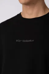 Remerón de corte oversized confeccionado en tejido rústico, con cuello redondo y mangas cortas. Presenta un diseño minimalista con una pequeña estampa frontal centrada en el pecho.