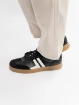 Championes urbanos modelo Osaka, confeccionados en poliuretano color negro con detalles en blanco en los laterales y suela de goma en tono tostado.