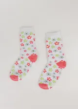 Par de medias blancas de media caña con estampado de flores rojas, azules y verdes, con puntera y talón color coral.
