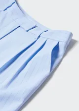 Pantalon de vestir de corte recto y tiro alto, color celeste con estampado de raya diplomática. Cuenta con bolsillos laterales, bolsillos traseros de ribete y cierre frontal oculto.