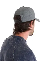 Gorro tipo baseball gris con efecto lavado, con el logo de Caterpillar bordado en amarillo en la parte frontal. Cuenta con visera curva y cierre metálico ajustable en la parte trasera.