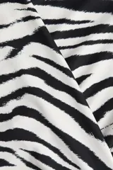 Vestido mini de manga larga en punto elástico con escote cruzado en V, corte ajustado y diseño drapeado en los laterales.