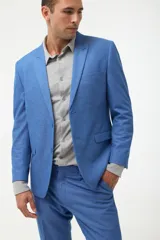 Ambo de vestir color azul, compuesto por saco con solapa en punta y pantalón a juego. El saco cuenta con cierre frontal de dos botones y bolsillos laterales con solapa.