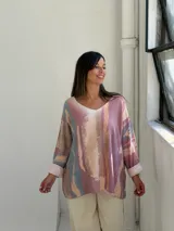 Sweater de punto con diseño abstracto en tonos rosados, beige y azul, de corte holgado, cuello en V y mangas largas con puños vueltos.