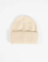 Gorro tejido de punto fino en color beige, con diseño de canalé y borde doble doblado.