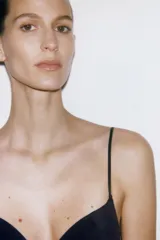 Top negro con escote corazón y tirantes finos ajustables. Presenta detalle de entredos a tono en el cuerpo y bajo redondeado.