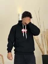 Canguro negro con capucha, de corte boxy, con estampa gráfica en la espalda que recrea el logo de Marlboro en rojo y blanco, junto con el escudo de Philip Morris y la leyenda 'Smoking kills' y 'FILTER BLACK'.