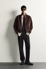 Cazadora bomber de corte regular fit en tejido efecto ante de color marrón oscuro, con cuello alto, cierre frontal de cremallera y bolsillos laterales de vivo.