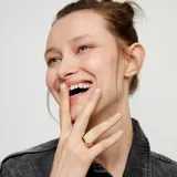 Anillo de aleación de metales bañado en oro de 18k, con forma redondeada y superficie lisa.