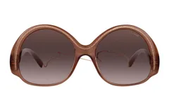 Lentes de sol Azzaro de edición limitada con armazón redondeado en tono marrón traslúcido y detalle de cadena metálica dorada en el borde superior. Cristales degradados en tono marrón.