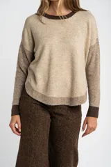 Sweater de punto con diseño color block en tonos beige, marrón y bordó, de cuello redondo y manga larga con puños acanalados en contraste.