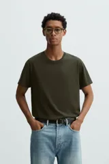 Camiseta de algodón de peso medio, color gris oscuro con efecto lavado ligero. Presenta cuello redondo y manga corta.