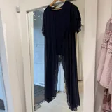 Blusa azul marino de gasa con mangas cortas abvolantadas y diseño asimétrico de largo midi.