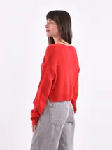 Sweater corto color beige con rayas horizontales negras, escote en V y mangas largas.