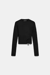 Top corto y ajustado de punto canalé color negro, con cuello redondo, manga larga y detalle de aplique metálico en la parte delantera.