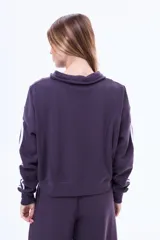 Buzo de felpa color marrón con medio cierre frontal, cuello alto y mangas largas con dos franjas blancas laterales.