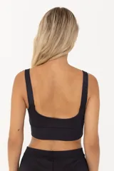 Top deportivo negro con tirantes anchos y largo intermedio. Cuenta con compresión media y espacio para agregar tazas.