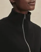 Buzo deportivo negro de corte oversize, confeccionado en tejido DoubleSoft®. Presenta cuello con paneles, media cremallera metálica y puños y bajo amplios.