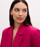 Blazer sastre de corte alargado y diseño minimalista sin botones. Presenta cuello con solapas clásicas, mangas largas y bolsillos laterales tipo vivo. Confeccionado en tejido estructurado con forro interior.