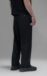 Pantalón cargo de corte oversize confeccionado en microfibra técnica con sutil elasticidad. Presenta cintura elástica, bolsillos laterales y un bolsillo cargo con cierre de broche snap. Incluye un sistema de elásticos con tancas en los tobillos para regular la apertura y la silueta.